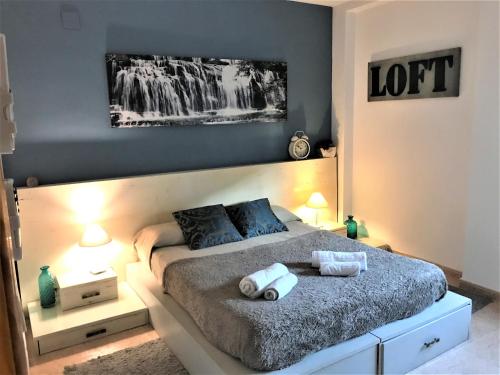 een slaapkamer met een bed met twee handdoeken erop bij Apartamento junto al río en entrada ruta Cahorros in Monachil