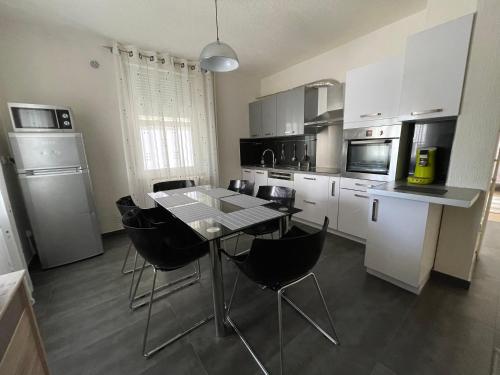 - une cuisine avec une table et des chaises noires dans l'établissement Appartement Bes,, Chaleureux et confortable avec entrée indépendante, à Wittenheim