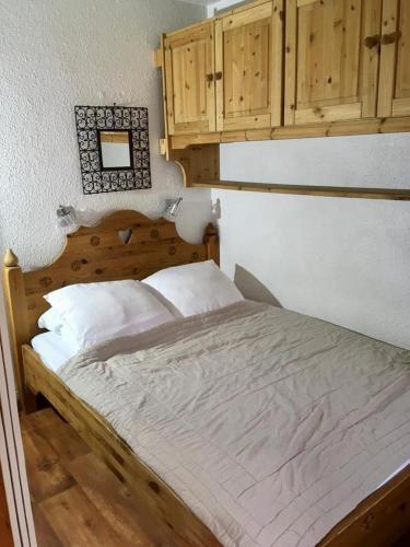 Ce lit se trouve dans une chambre dotée d'armoires en bois. dans l'établissement CHAMONIX CENTRE le Grepon, à Chamonix-Mont-Blanc