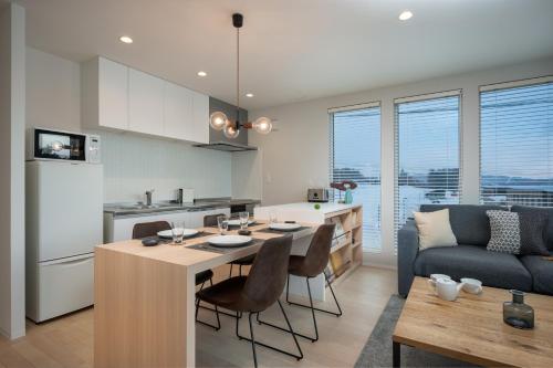 富良野的住宿－ArtHouse by H2 Life，厨房以及带桌子和沙发的客厅。