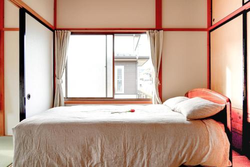 a bedroom with a bed with a large window at Second House Nikko in Nikko