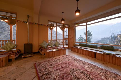 a living room with a view of the mountains at Zostel Dobhi, Manali in Nagar