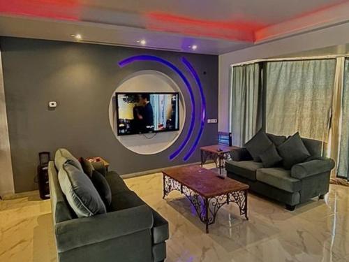 a living room with two couches and a round mirror at فيلا بمسبح خاص درة العروس in Durat  Alarous