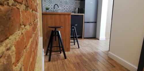 a kitchen with a counter and two bar stools at Rooms by Apartamenty Lubartowska Street in Lublin