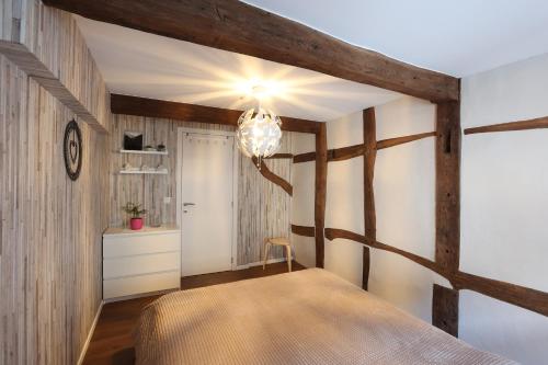 1 dormitorio con 1 cama y pared de madera en Le cosy 40 - maison typique au centre de Malmedy en Malmedy