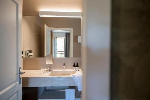 a bathroom with a sink and a large mirror at Hotel Weingut Stroblhof in Appiano sulla Strada del Vino