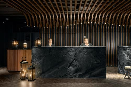 two people standing in front of a counter in a room at Lapland Hotels Arena in Tampere
