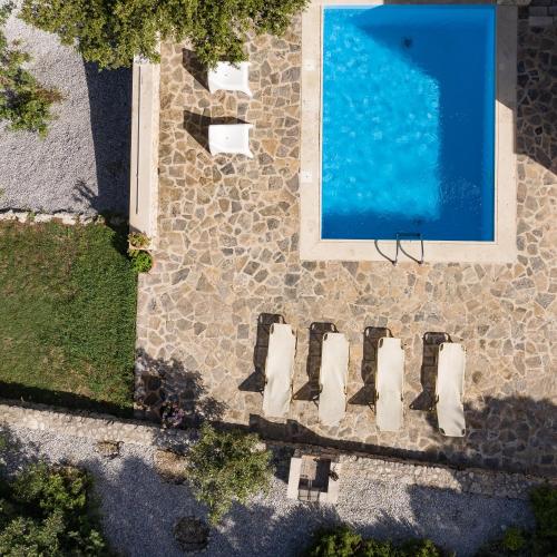 an overhead view of a swimming pool next to a house at Koules Estate, with Private Pools & BBQ - embracing Nature, By ThinkVilla in Argoulión