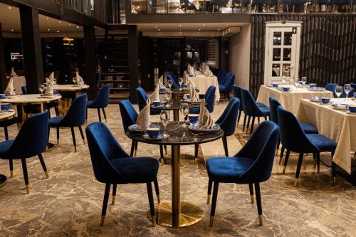 a dining room with tables and chairs and tablesktop at Orient Hotel Bishkek in Bishkek