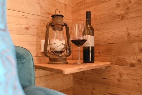 a bottle of wine and a glass on a shelf at Salzgeber Appartements in Sankt Gallenkirch