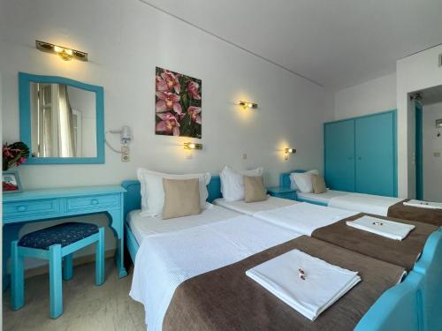 a hotel room with two beds and a mirror at Stratos Hotel in Pythagoreio