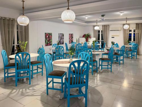 a dining room with blue chairs and tables at Stratos Hotel in Pythagoreio