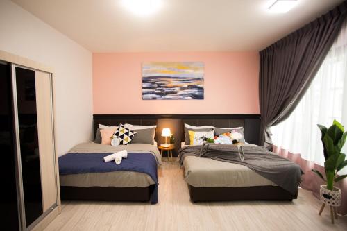 新山的住宿－Suasana suites By The one，配有粉红色墙壁的客房内的两张床