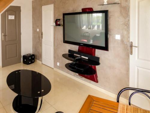 un salon avec une télévision sur un mur dans l'établissement Les Mystères D'Omaha Beach, à Surrain