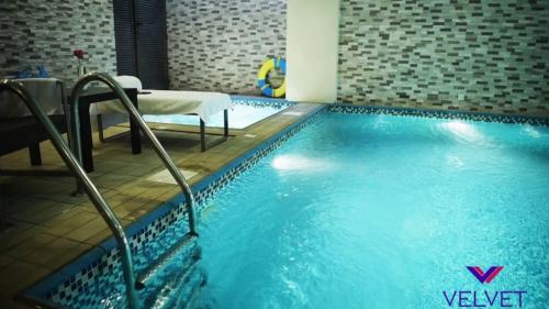a large swimming pool in a hotel room at Velvet Hotel Jeddah in Jeddah