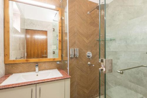 a bathroom with a sink and a glass shower at StayVista at SilverOaks Cottage in Dehradun