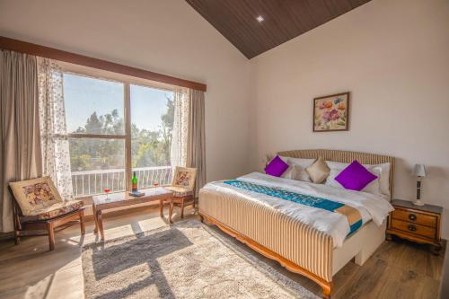 a bedroom with a bed and a large window at StayVista at SilverOaks Cottage in Dehradun