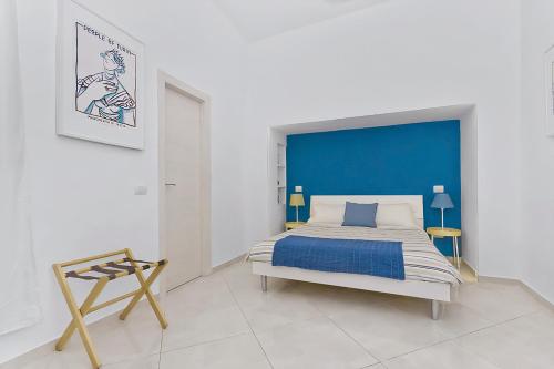 a bedroom with a bed with a blue headboard at Blunotte Torino - Piazza Castello in Turin