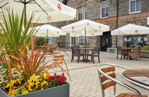 a patio with tables and chairs and umbrellas at Malmaison Aberdeen in Aberdeen