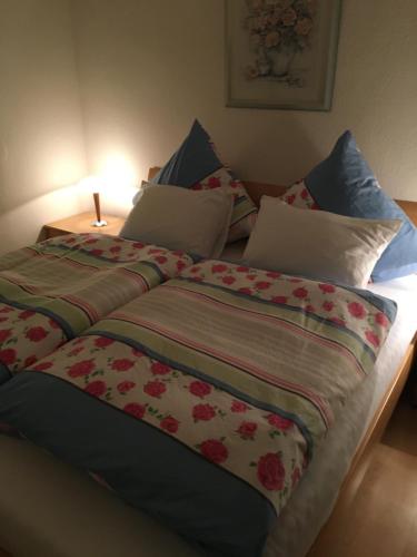 a bed with a blanket and pillows on it at B&B Villa Altero in Pünderich