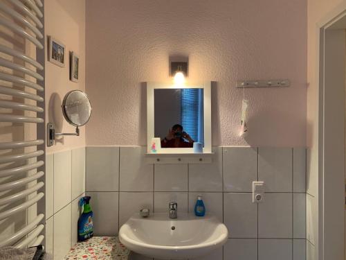 une personne prenant une photo d'une salle de bains avec lavabo dans l'établissement Gleich neben Dom und Schloss, à Limburg an der Lahn