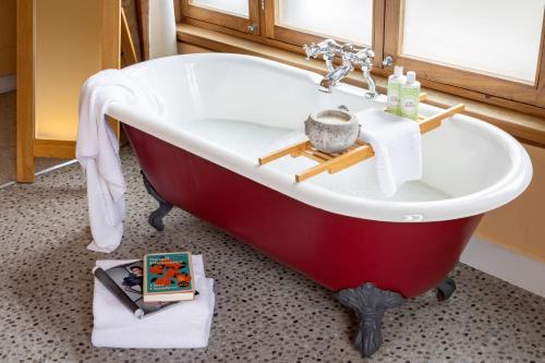 a red and white bath tub in a bathroom at Spot in the Woods in Lyndhurst