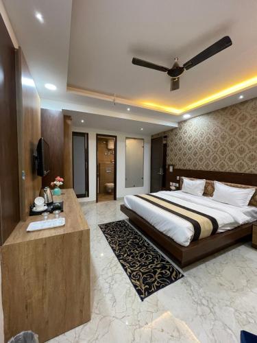 a bedroom with a large bed and a television at Maps Inn in Ghaziabad