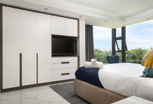 a bedroom with a large bed and a tv at 1 Licorna Beach in Durban
