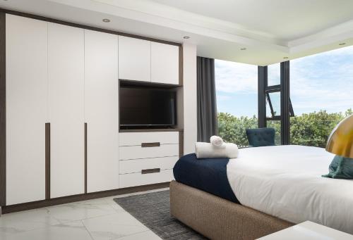 a bedroom with a large bed and a tv at Licorna Beach in Durban