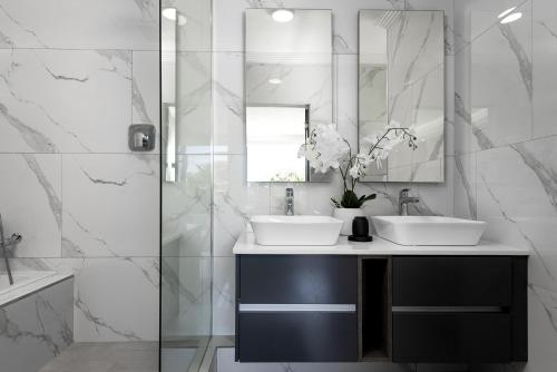 a bathroom with two sinks and a mirror at 1 Licorna Beach in Durban