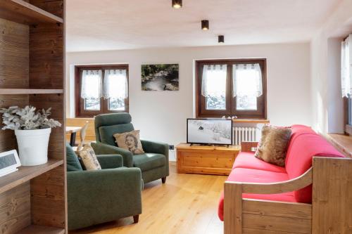 een woonkamer met een bank en een tv bij HelloChalet - Maison Mont Fleury- newly refurbished 50 mt center and ski bus stop in Valtournenche