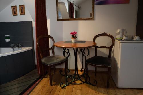 uma pequena mesa e duas cadeiras numa cozinha em The Only One Suites em Niš