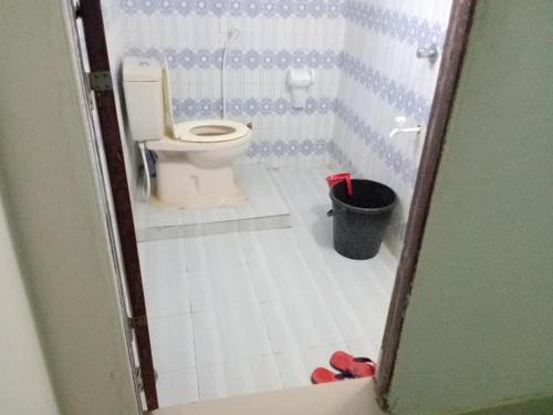 a bathroom with a toilet and a trash can at Eque Heritage Hotel & Resort in Lakshmanpur Bālāpāra