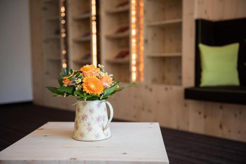 a vase filled with flowers sitting on a table at Wohlfühlhotel Frohsinn in Fischen
