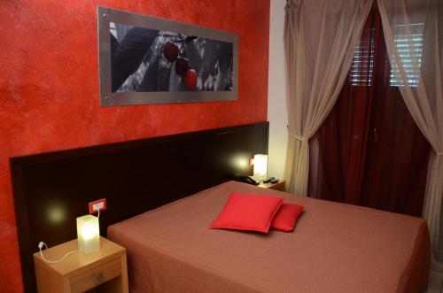 una camera con un letto con una parete rossa di Agriturismo Tenuta Chianchizza a Monopoli
