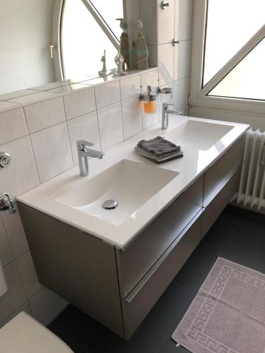 a bathroom with a white sink and a window at Maisonette am Belchen in Bad Krozingen