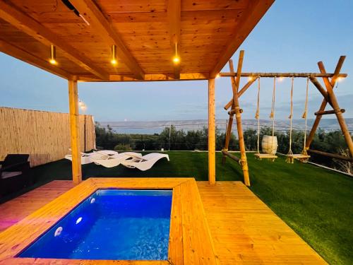 una casa con piscina en una terraza en נוף המצוק en Poriyya