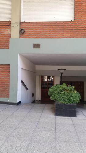 um edifício com um vaso de plantas em frente a um edifício em Depto. Chauvin em Mar del Plata