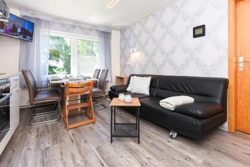 a living room with a black couch and a table at Ferienhof Tannen in Stedesdorf