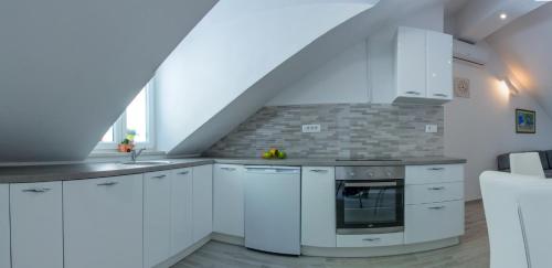 a kitchen with white cabinets and a staircase at Apartment Ma_Lu in Pučišća