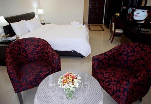 a hotel room with a bed and a table and chairs at soi2inn in Pattaya Central