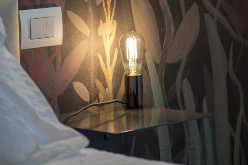 a lamp sitting on a table in a bedroom at Habitat Apartments in Trento