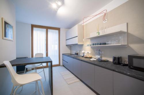 a kitchen with a counter and a table and chairs at Habitat Apartments in Trento