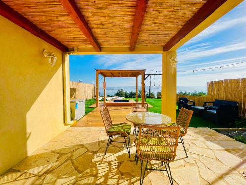 a patio with a table and chairs on a patio at נוף המצוק in Poriyya Illit