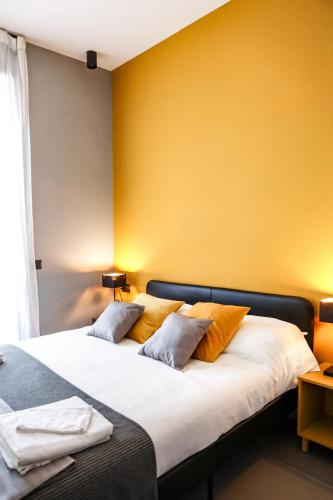 two beds in a room with a yellow wall at Materdays 24 in Naples
