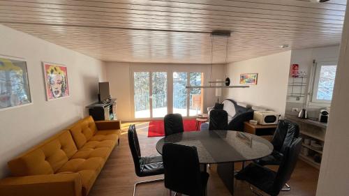 a living room with a table and a couch at Haus Alpenblick A5 - CharmingStay in Flumserberg