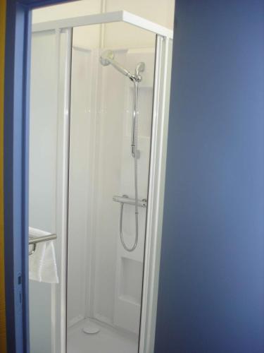a shower with a glass door in a bathroom at Hôtel des Sables Blancs in Douarnenez