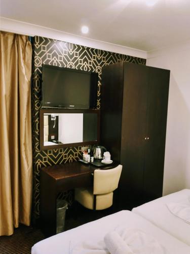 a hotel room with a desk and a mirror at Hotel Edward Paddington in London
