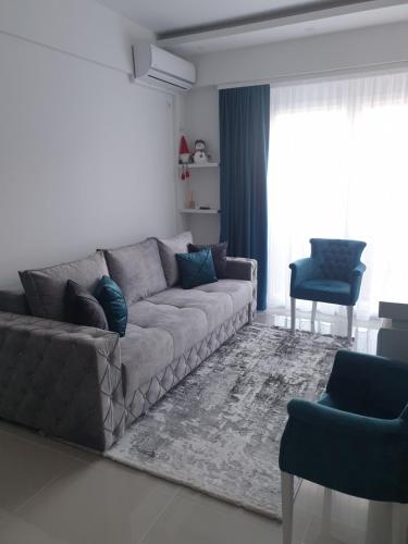 a living room with a gray couch and blue chairs at LUX Apartment - Central Place Bar in Bar