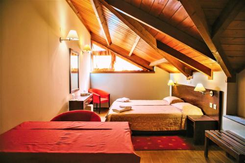 a hotel room with two beds and a window at Grand Hotel Dentro in Konitsa